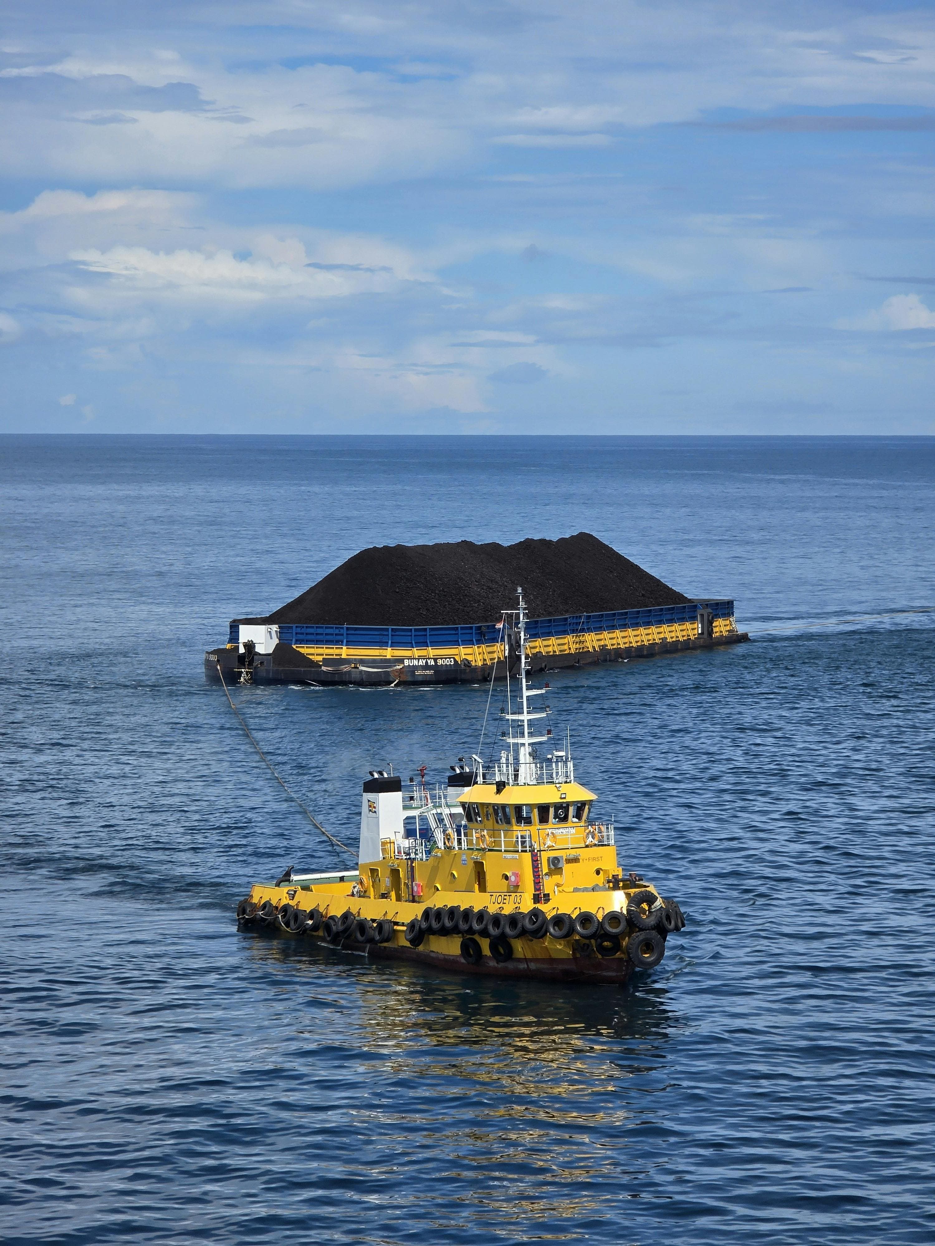 Tugboat assisting a loaded barge at sea